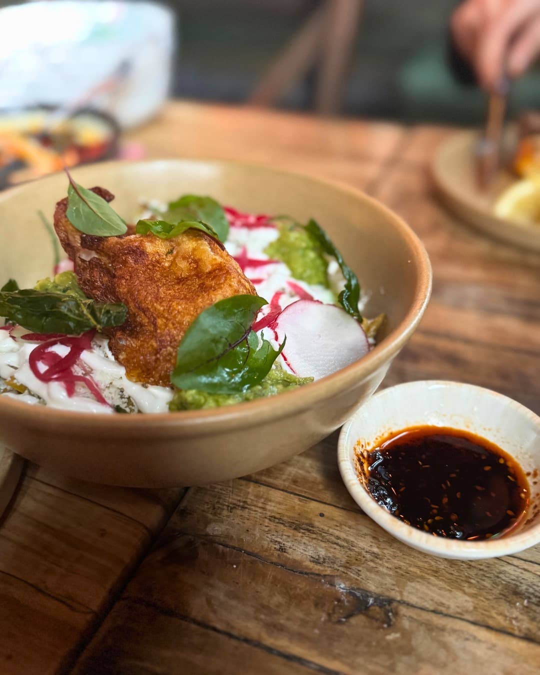 Warm bowl of food served with a side dish of salsa macha.